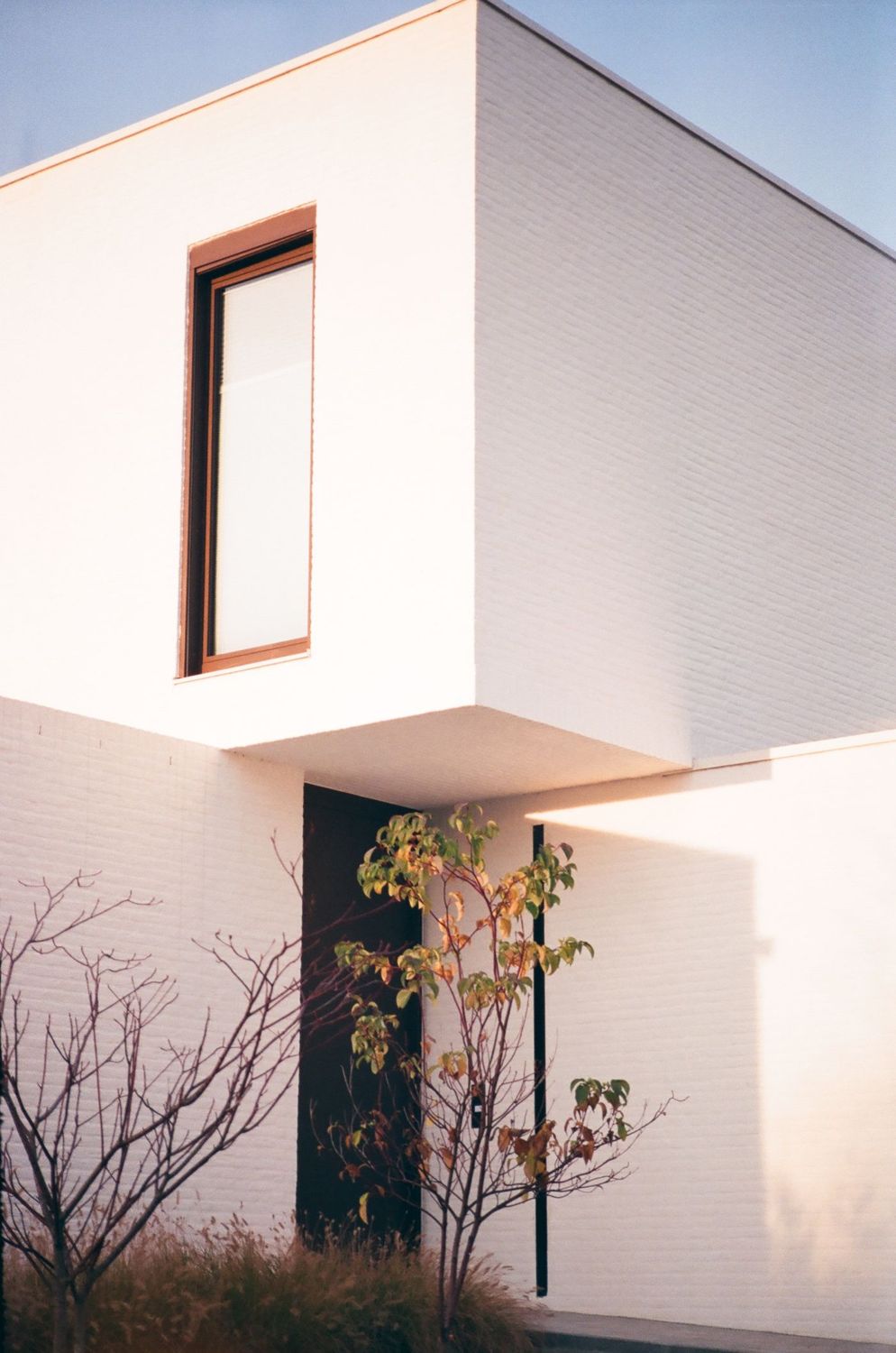 Wit modern huis met strakke gevel en een raam